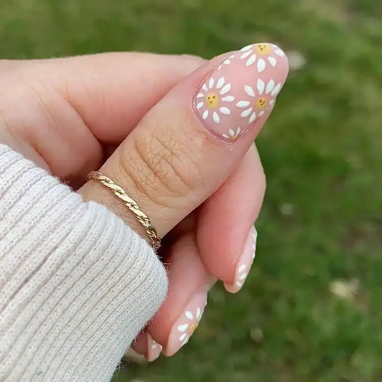 Whimsical daisy acrylic nails with tiny, hand-painted smiley faces, perfect for a cheerful spring look.