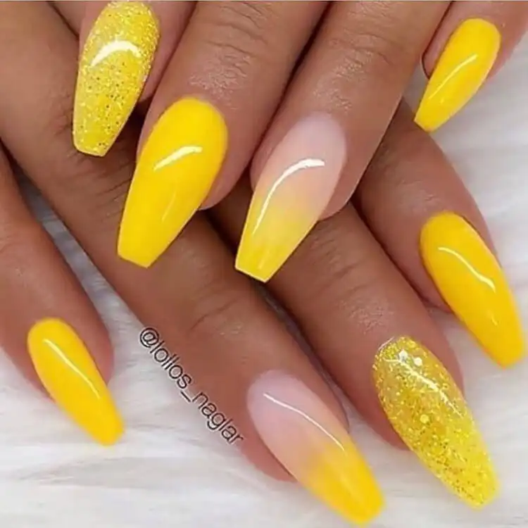 Bright yellow and glitter acrylic nails, with each nail showcasing a different, complementary design.