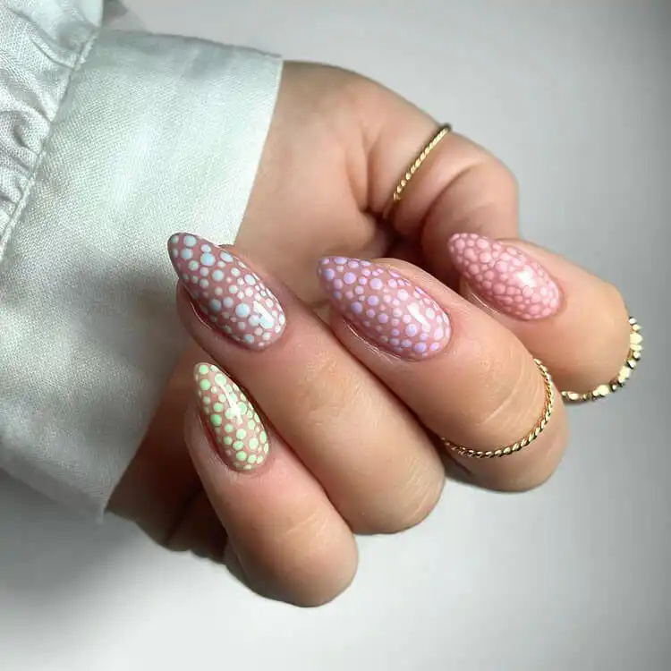 Perfect spring acrylic nails with soft pastel dots over a light base, a charming and elegant pattern.