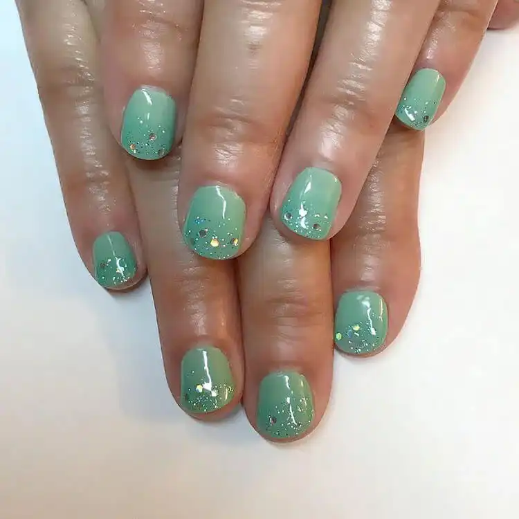 Turquoise natural nails embellished with delicate rhinestones, showcasing simple yet elegant beauty.