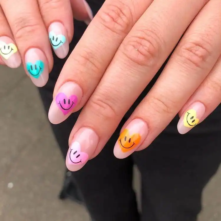 Cheerful happy heart and smiley face acrylic nail art, radiating positivity with bright colors and playful motifs.