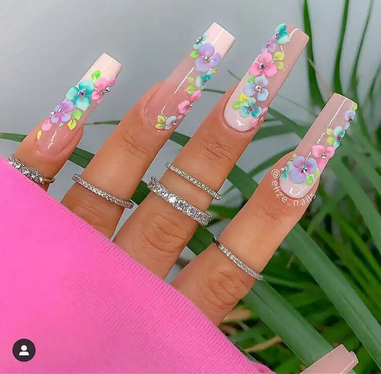 Extravagant acrylic nails adorned with intricate 3D flowers, adding depth and a luxurious texture to the manicure.
