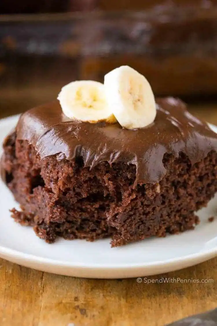 A slice of moist Chocolate Banana Cake with a rich chocolate glaze.