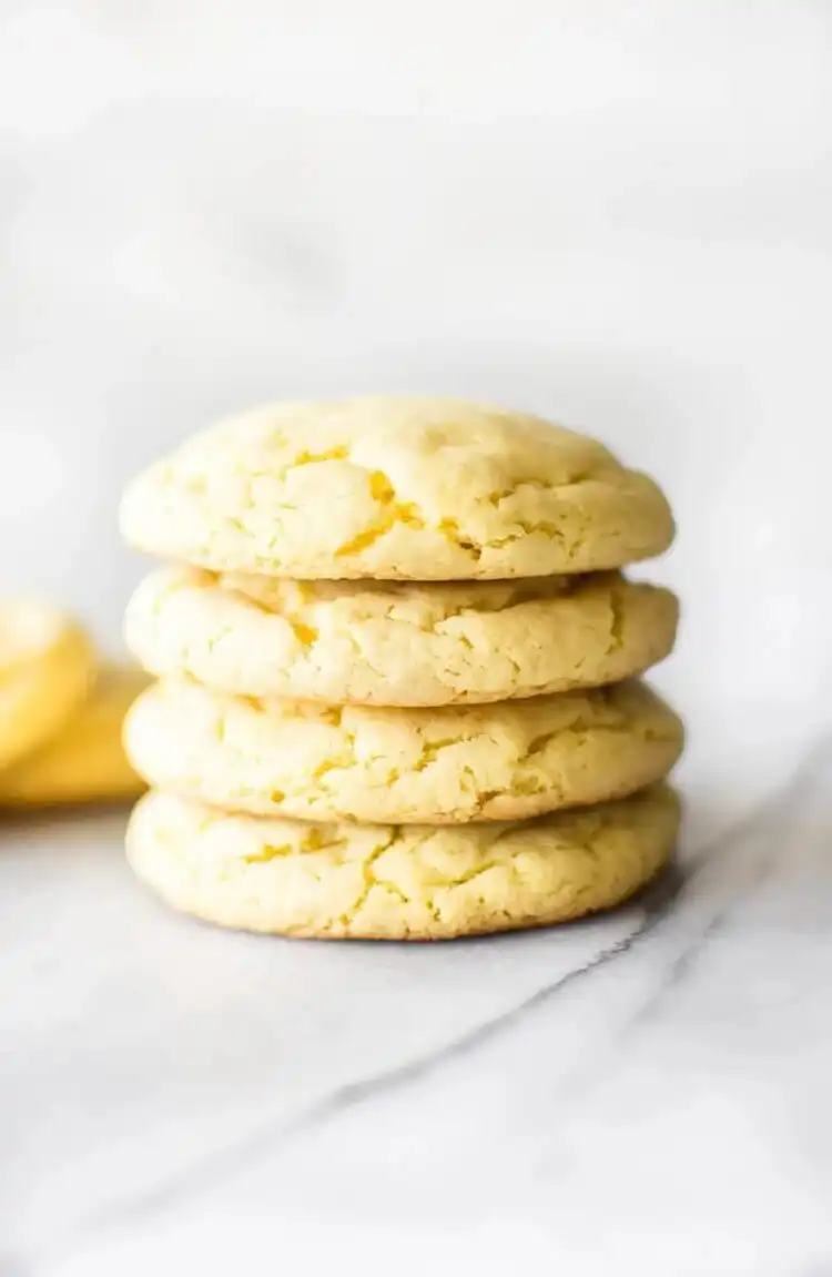 Bright yellow Lemon Cake Mix Cookies with a crinkled texture, dusted with powdered sugar.