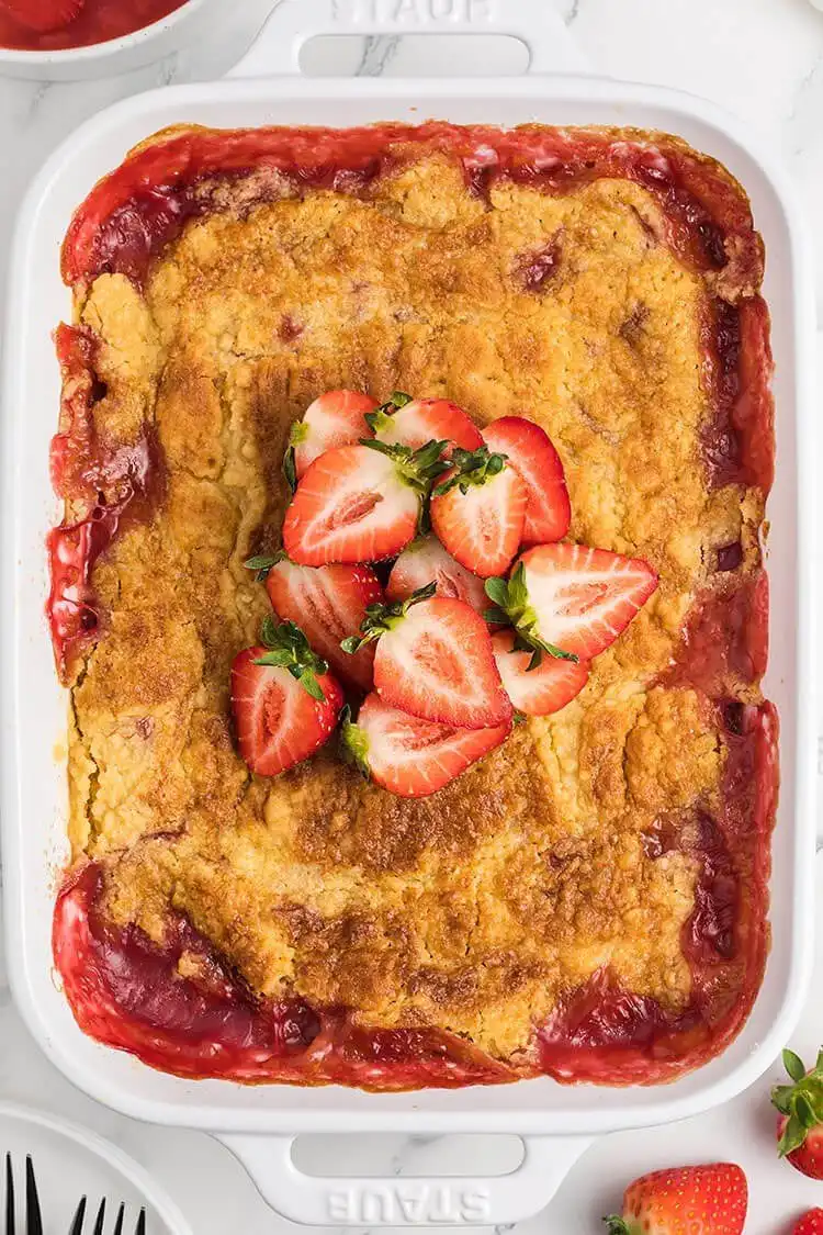 A vibrant Strawberry Dump Cake in a pan, showcasing the rich strawberry filling.
