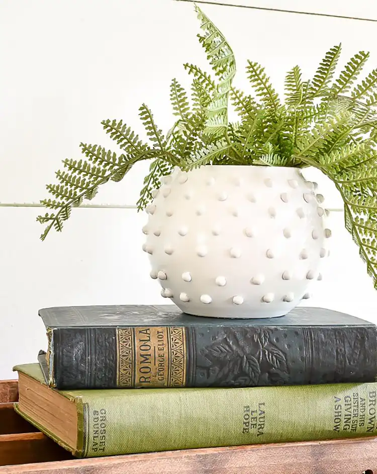 Clear glass vases painted and textured to resemble vintage hobnail milk glass, holding delicate flowers.