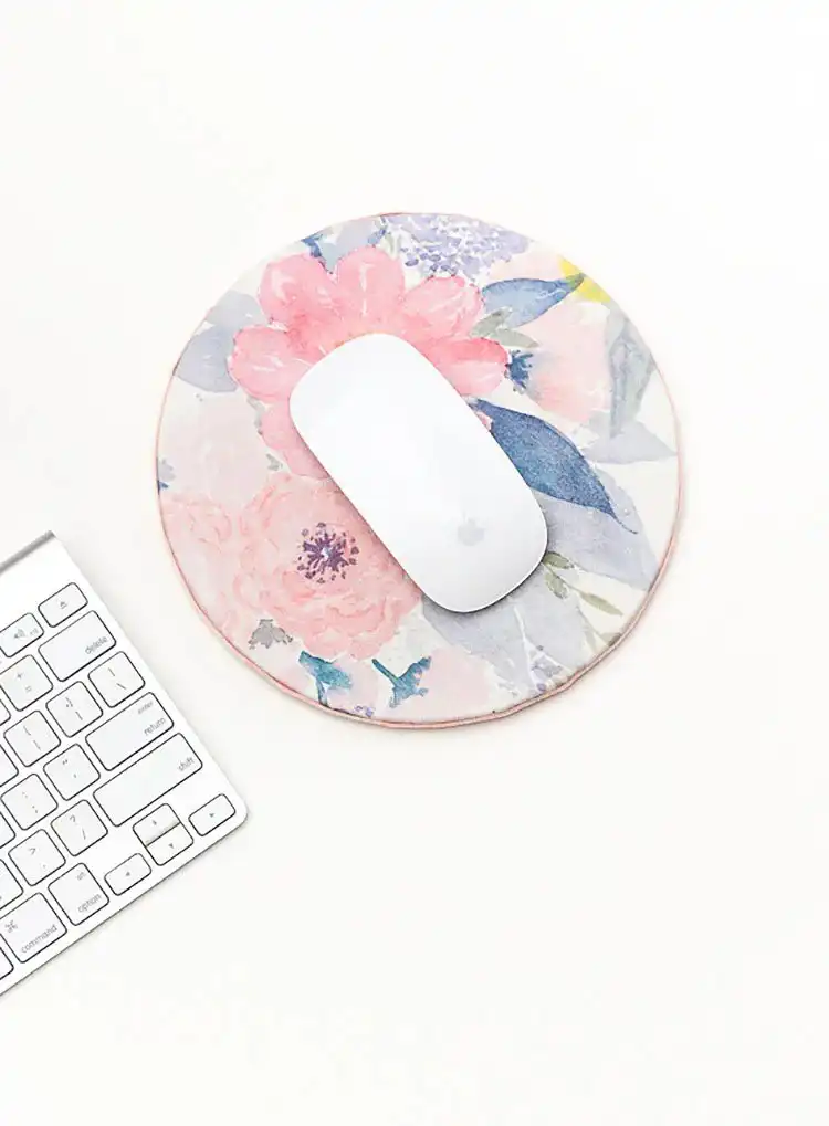 A computer mouse pad decoupaged with a beautiful floral fabric, adding a personalized touch to a desk setup.