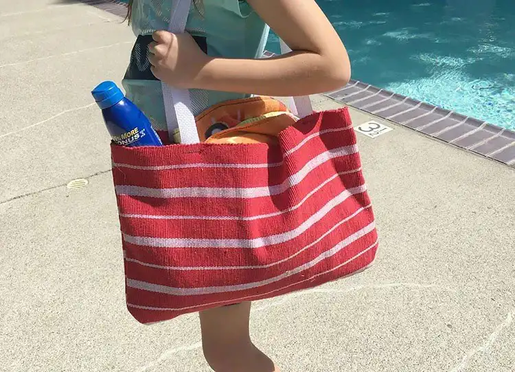 A stylish tote bag constructed from two patterned dollar store placemats, perfect for beach trips or shopping.