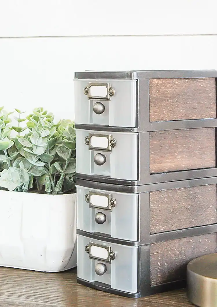 A small wooden storage drawer with industrial farmhouse accents, made from dollar store supplies, holding small items.
