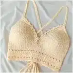 Woman wearing a cream Luna Crop Top with simple triangle cups and a deep V neckline, modern boho style