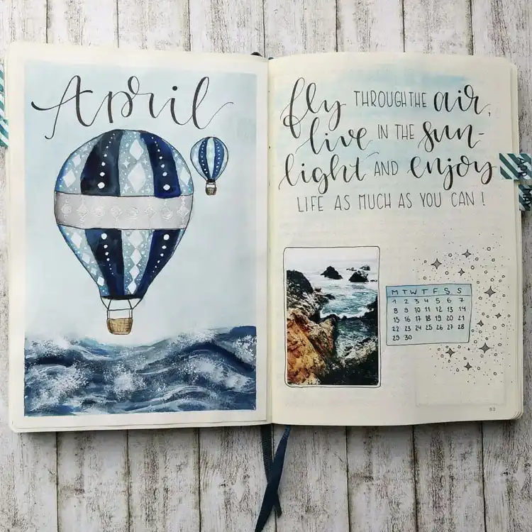 A blue hot air balloon April bullet journal cover page, showcasing beautiful gradients of blue and an uplifting quote.