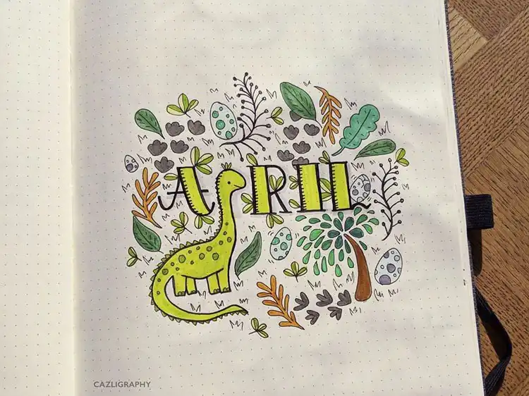 An April bullet journal cover page with playful dinosaurs nestled among green plants, in a blue and green scheme.