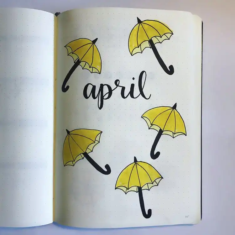 A simple April bullet journal page adorned with cheerful yellow umbrellas.