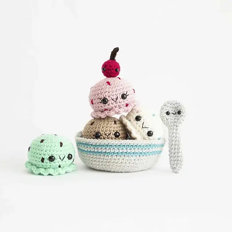 A crocheted s'mores plushie, depicting a toasted marshmallow, chocolate, and graham cracker.