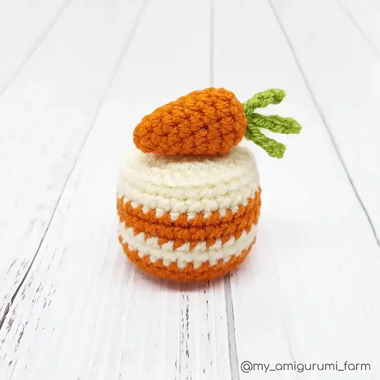 An amigurumi ice cream sundae in a bowl, complete with scoops, sprinkles, and a cherry.