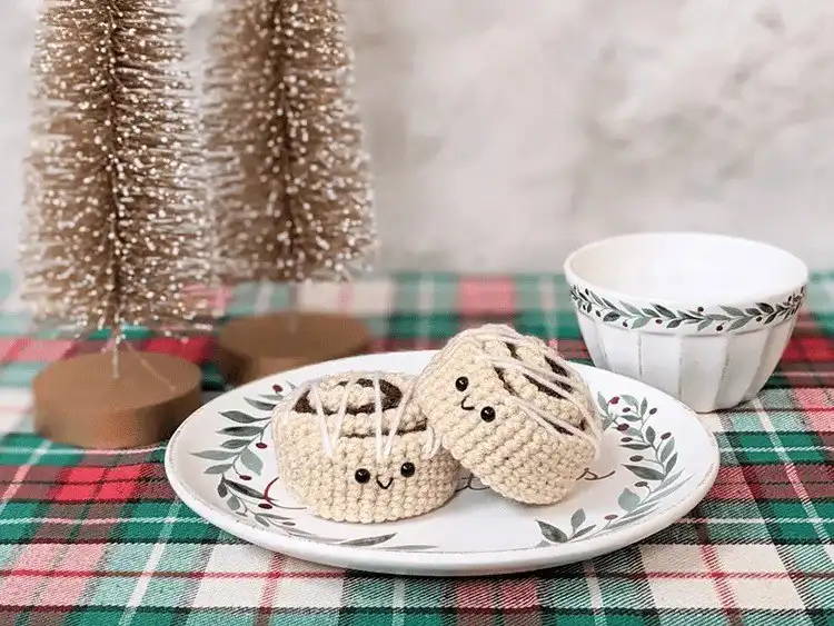 A crocheted cinnamon roll, showing its distinctive swirl and 'frosting' details.