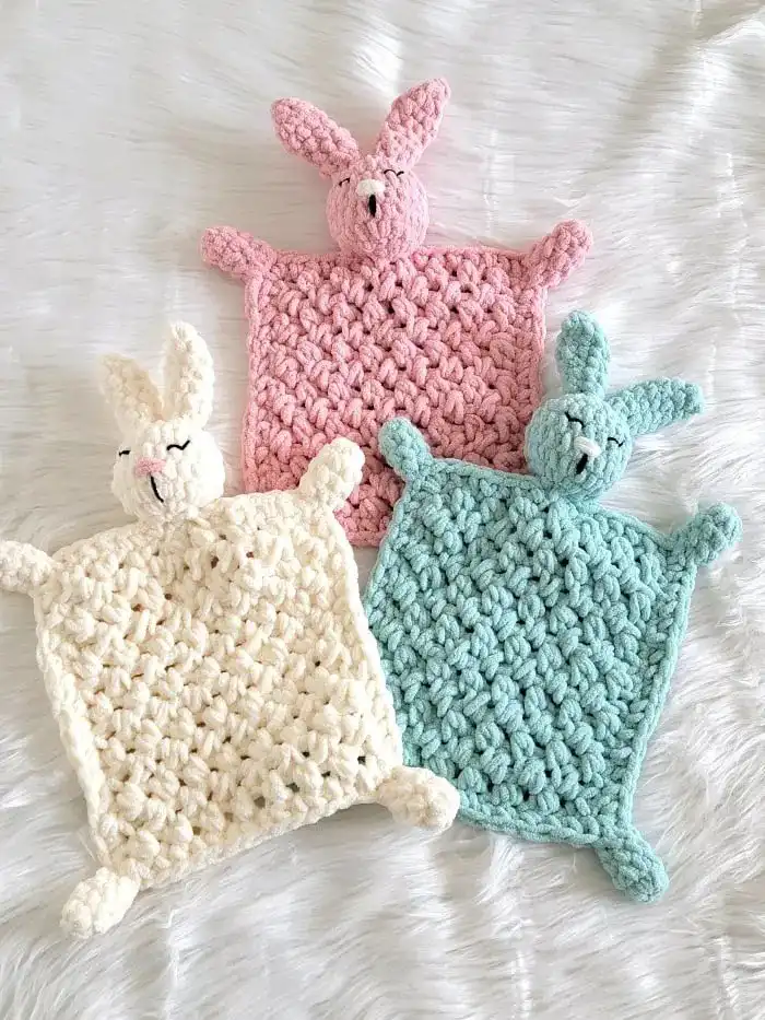 Beginner-Friendly Free Bunny Lovey Crochet Pattern Baby Gift 4 Three crochet bunny loveys in pink, blue, and cream colors, showcasing variety.