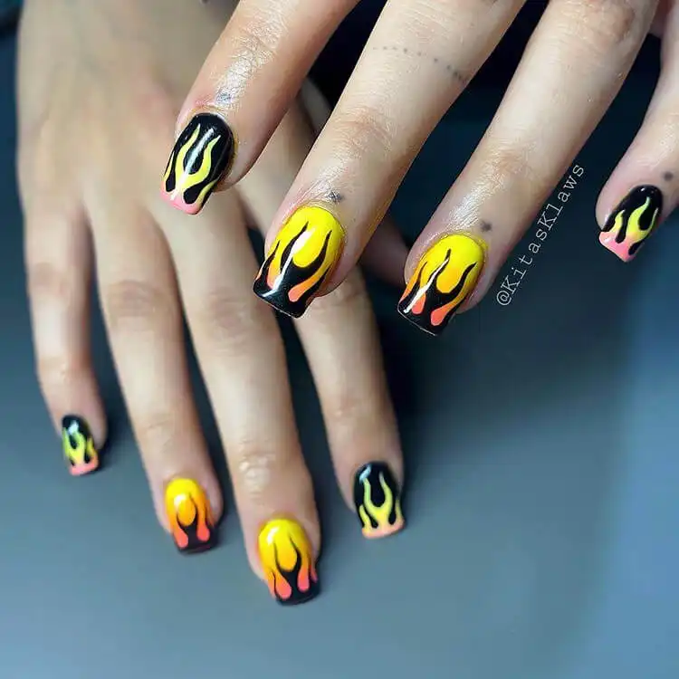 Black Nail Designs - Black Flames and Checkerboard 13 Black and yellow flame nails with hints of orange creating a vibrant, fiery appearance.