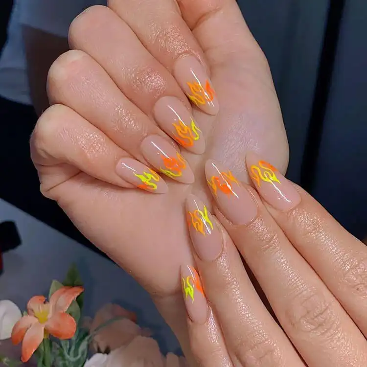 Black Nail Designs - Black Flames and Checkerboard 8 Nude nails with flame outlines in bright orange and yellow, for a subtle fiery look.