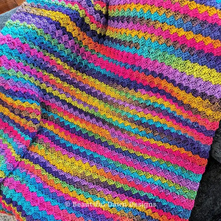 Blooming Hues Crochet Blanket Pattern laying flat, showcasing the full expanse of the finished fabric and its consistent, appealing texture.