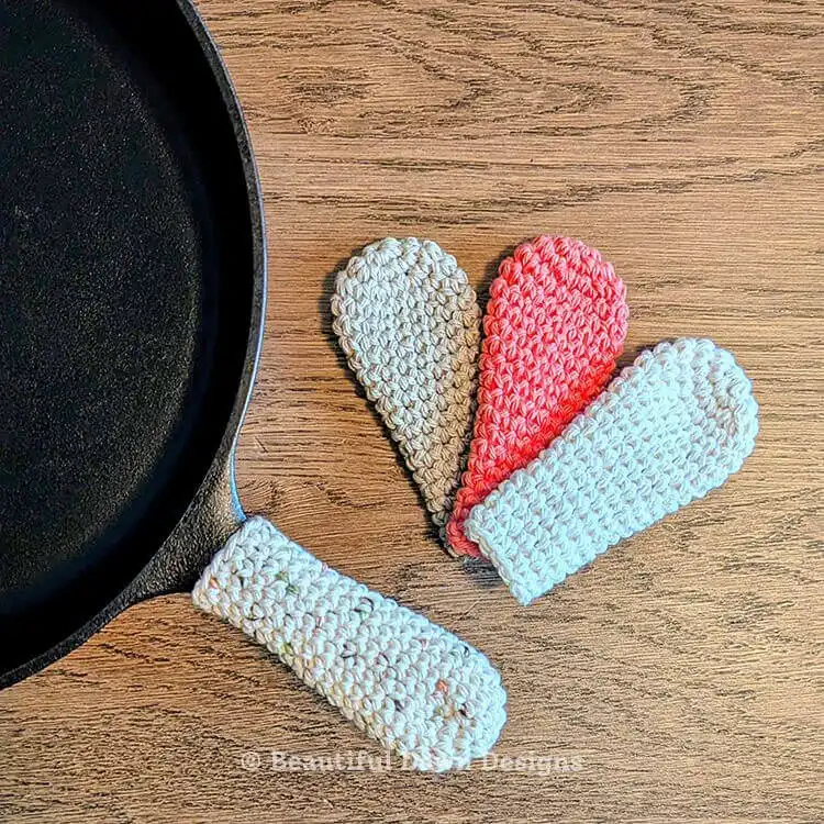 A zoomed-out view of the Cast Iron Skillet Handle Cover Free Crochet Pattern project, highlighting its overall shape and size, next to essential crochet tools like a hook and yarn, emphasizing its utility as a Crochet Gift Idea.