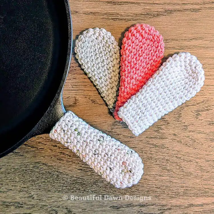 Multiple crocheted Cast Iron Skillet Handle Covers in various vibrant colors, showcasing the versatility and customization options of this Free Crochet Pattern, making it an appealing Crochet Gift Idea for different kitchen styles.