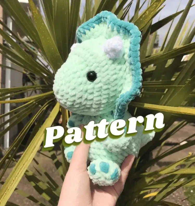 Trendy crochet Toby the Triceratops plush, made with soft, chunky yarn in a modern style, ideal for cuddles and decor.