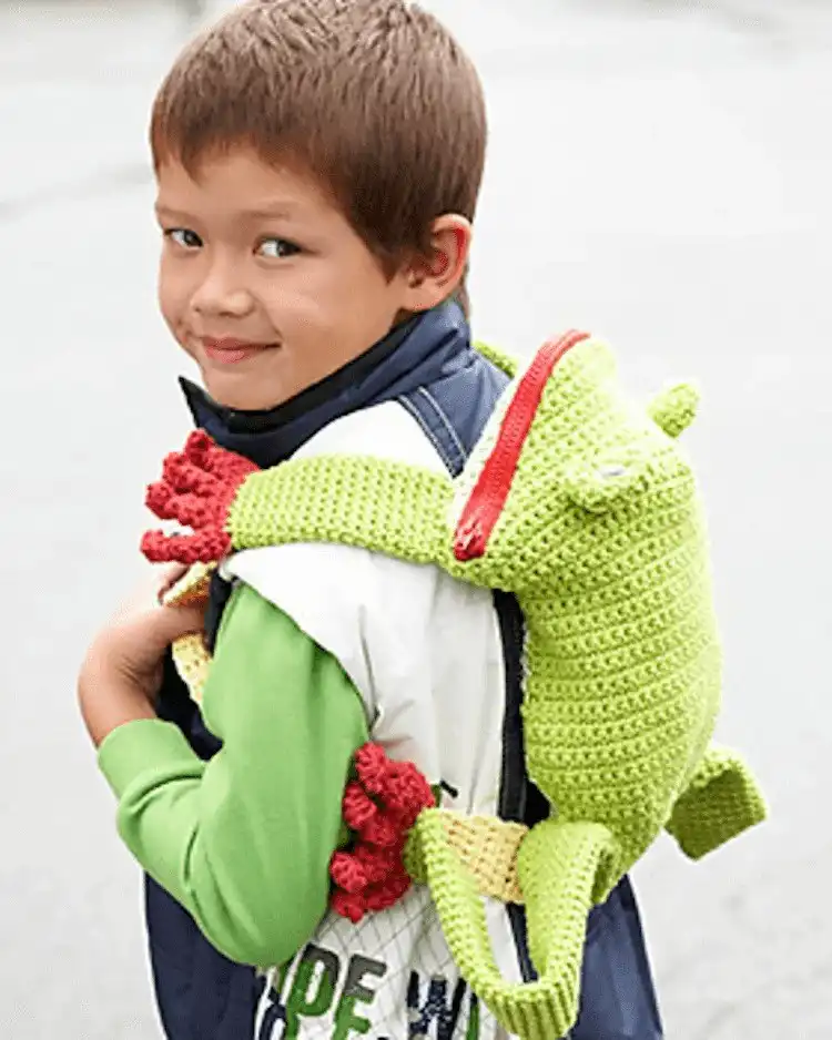 Child's green crochet Frog Backpack with large eyes and a friendly smile, ready for school