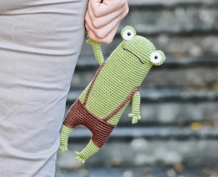 Simple, friendly green crochet Fred the Frog amigurumi with a slight smile
