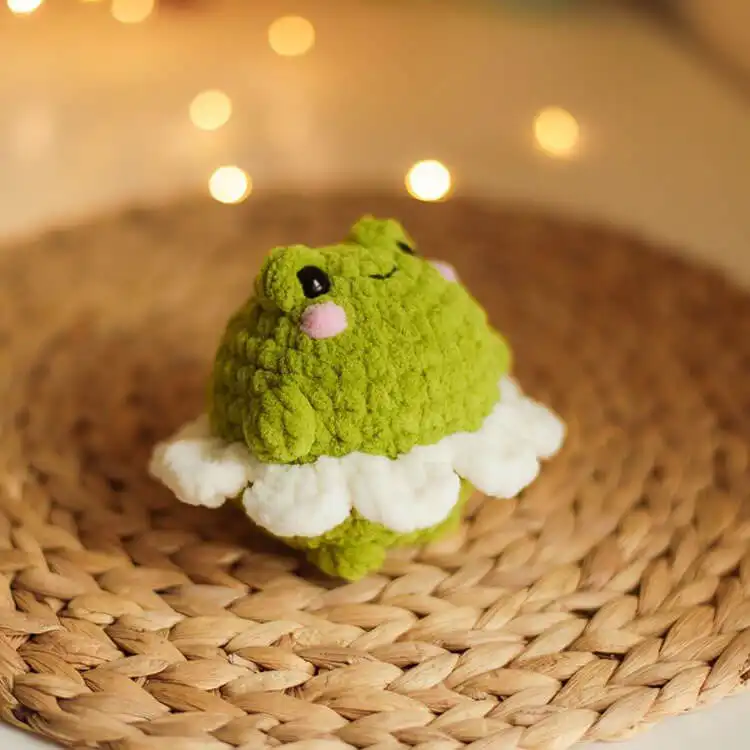 Whimsical crochet Frog Flower design, with a green frog sitting inside pink flower petals