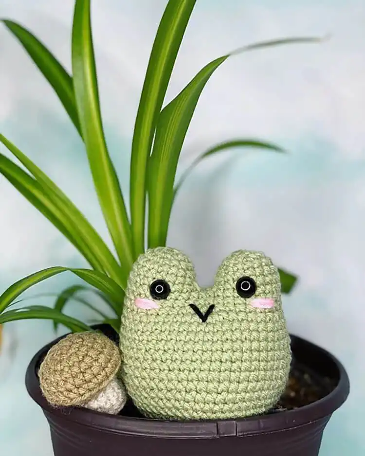 Squishy, round green crochet Frog Blob amigurumi with simple eyes and a smile