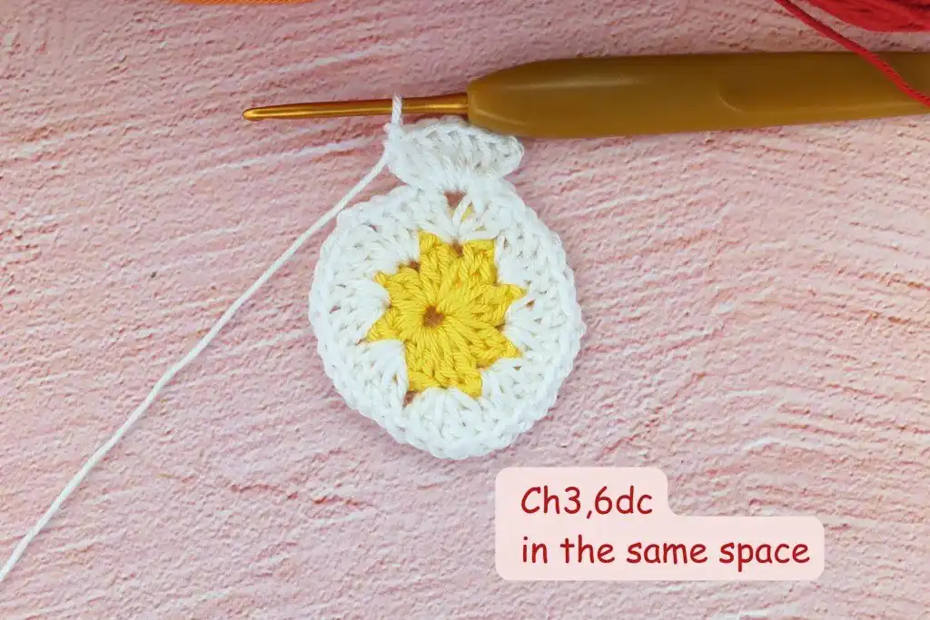 Photo tutorial of Round 2 in the African flower square crochet pattern, illustrating the (2dc, 1ch, 2dc) clusters in contrasting color, defining the petal bases.