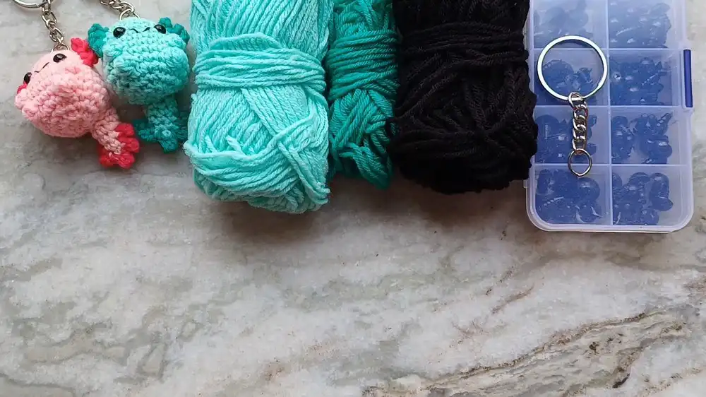 Lay-flat of all materials and tools required for the Crochet Baby Axolotl With Custom Gills and Bubble-Stitch Limbs project.