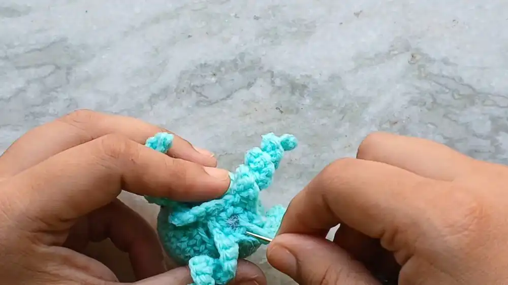 Detailed view of crocheted curly and straight tentacles attached to the jellyfish body.