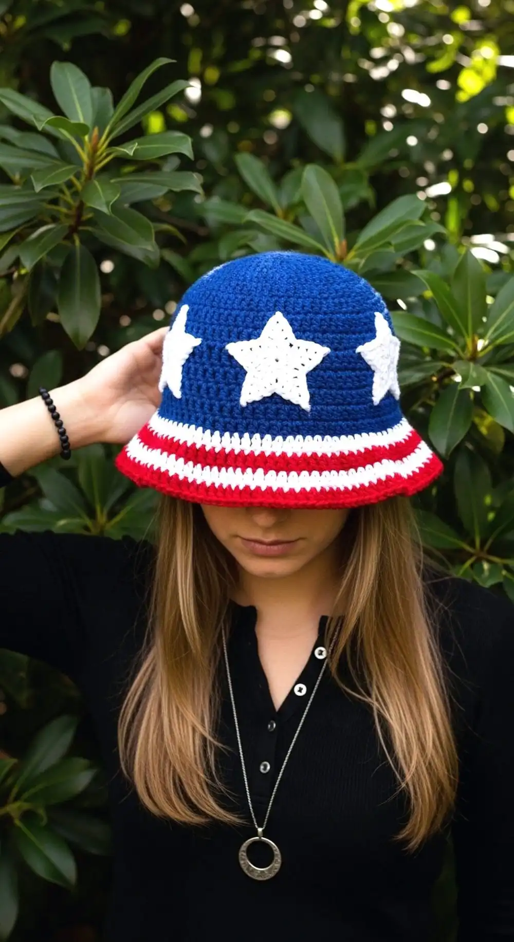 Crochet Patriotic Star Bucket Hat made from red, white, and blue star-themed granny squares, displayed on a wooden surface