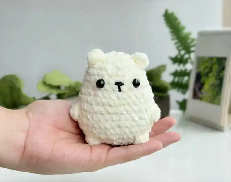 White no-sew polar bear crochet plushie with black eyes and nose.