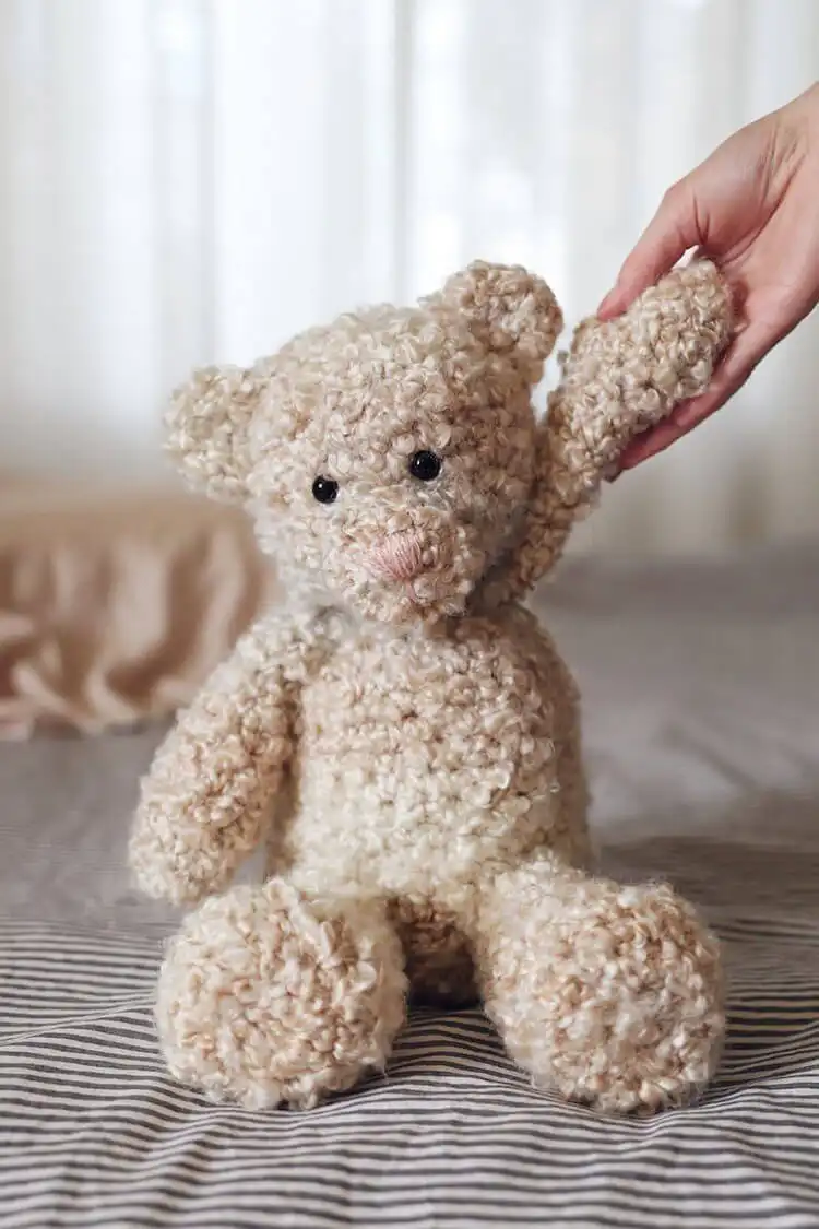 Classic brown crochet teddy bear with traditional button eyes and a friendly smile.
