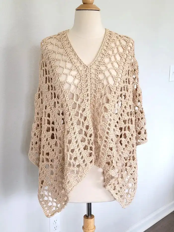 Crochet Lacy Summer Poncho styled with a V-neck on a mannequin, illustrating the flattering neckline and overall aesthetic for midsummer.