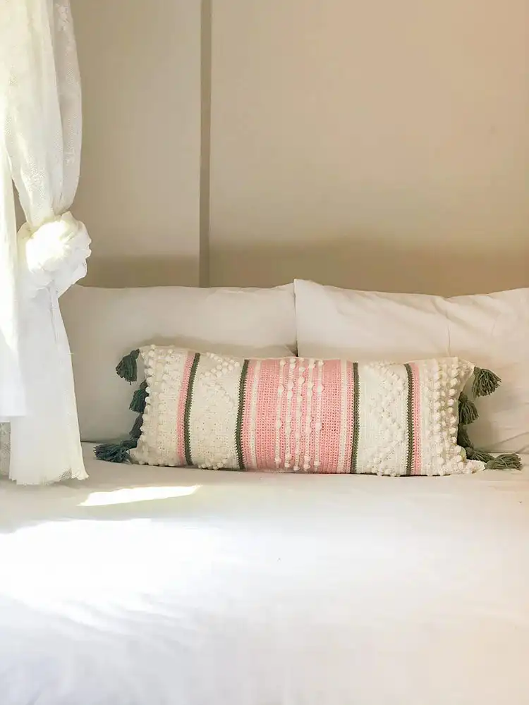 Long rectangular crochet pillow with textured stitches and contrasting color blocks, inspired by Anthropologie designs