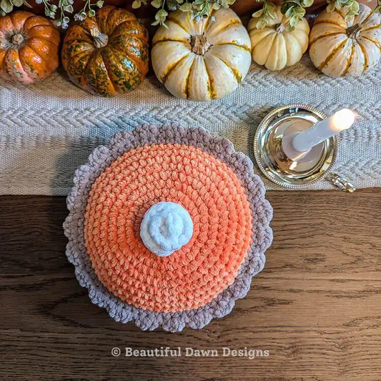 Realistic crochet pumpkin pie slice with whipped cream detail and a textured crust