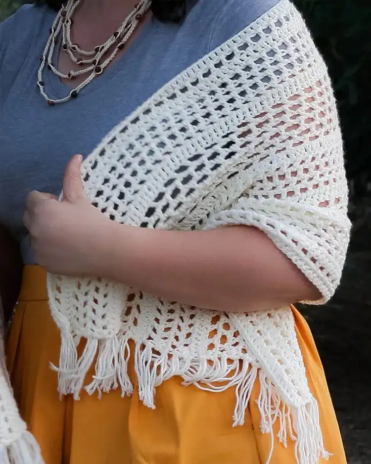 A simple yet elegant Boho Shawl in an off-white yarn, showing its relaxed drape and open stitches.