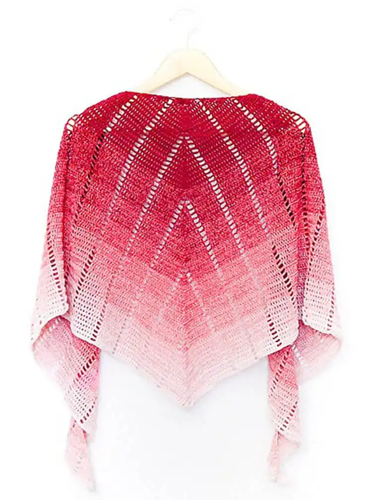 A stylish Raspberry Croissant Shawl with a unique crescent shape, made from a variegated yarn.