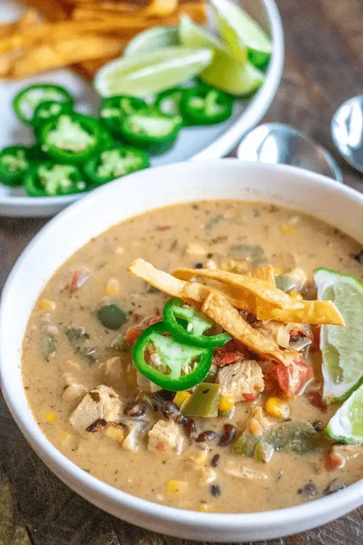 Creamy Chicken Tortilla Soup, garnished with fresh toppings, a comforting and flavorful soup, great alongside a Crockpot Chicken Nachos Recipe - Perfect Dinner Idea.