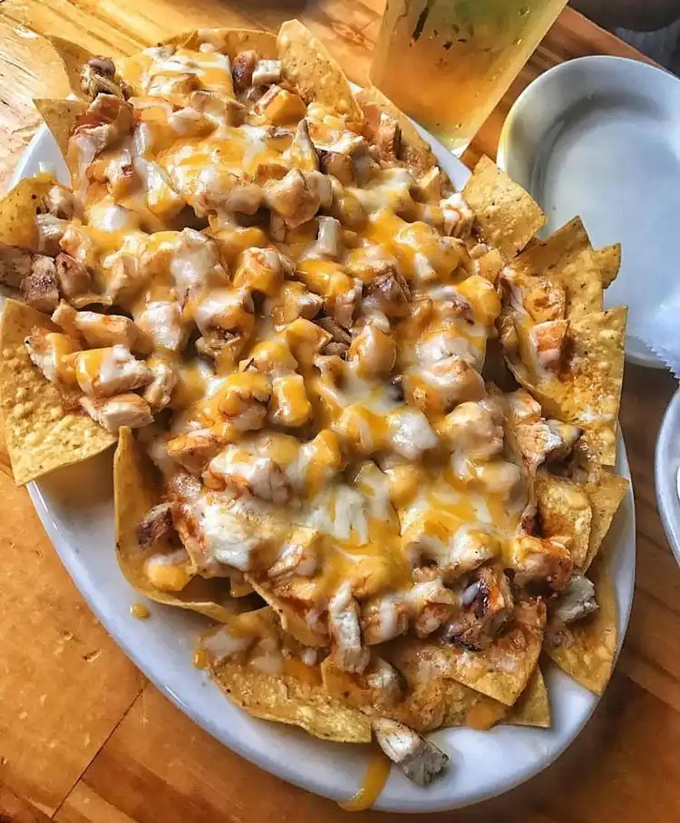 Overhead shot of Crockpot Creamy Chicken Nachos, loaded with cheese, chicken, and toppings, the ultimate Crockpot Chicken Nachos Recipe - Perfect Dinner Idea.