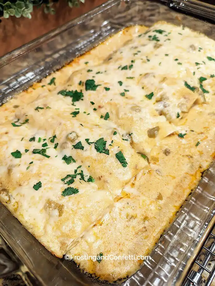 Creamy White Chicken Enchiladas, baked golden with smooth white sauce and seasoned chicken filling, a delicious Mexican-inspired Crockpot Chicken Nachos Recipe - Perfect Dinner Idea.