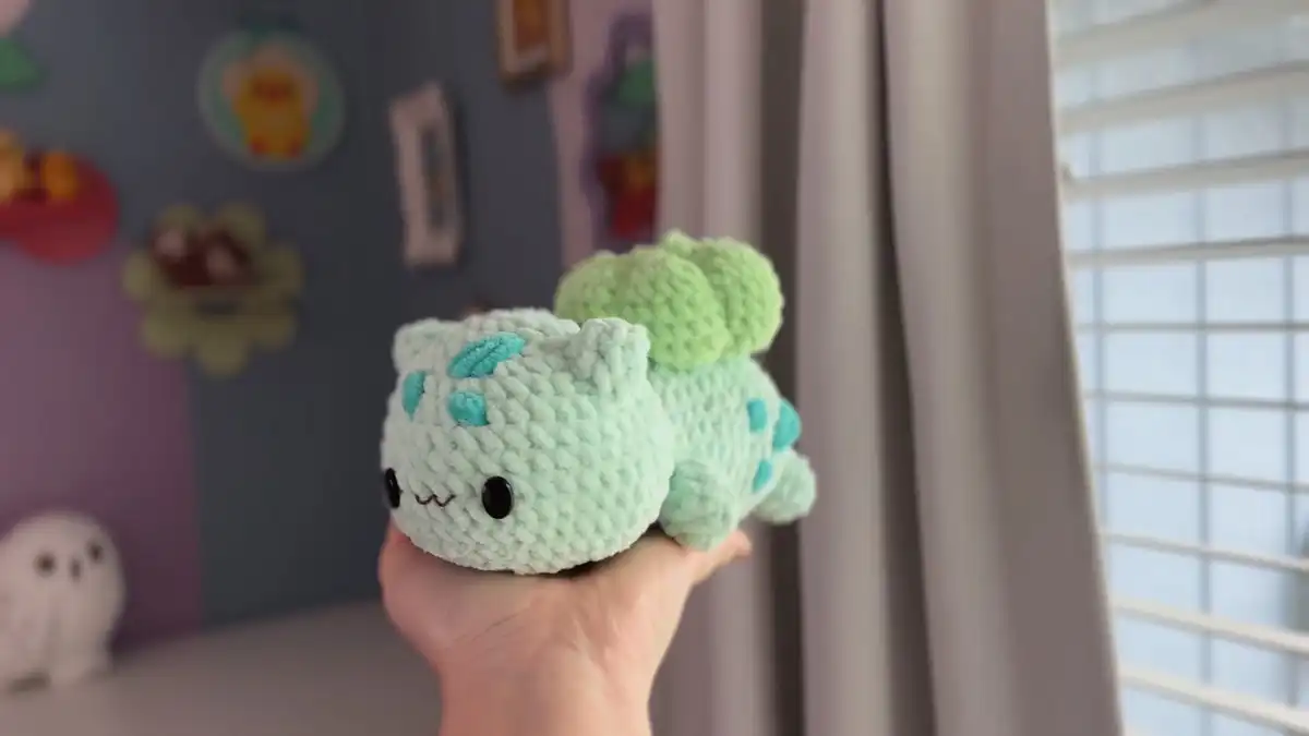 DIY Crochet Bulbasaur Pokemon Amigurumi Pattern 1 A finished DIY Crochet Bulbasaur Pokemon Amigurumi Pattern plush, showcasing its mint green body, green bulb, and cheerful embroidered face.