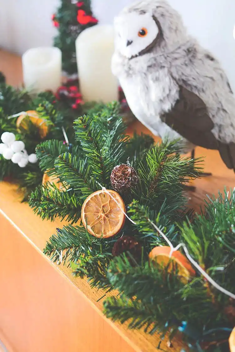 A close-up of a DIY Dried Orange Garland Made with Fragrant Botanicals, featuring cinnamon sticks, star anise, and bay leaves for a rich aroma.