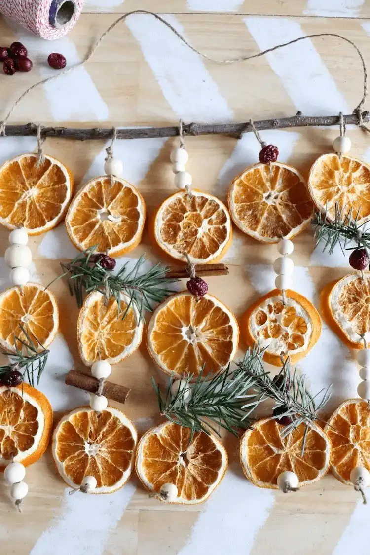 A Super Pretty Dried Orange Garland DIY draped over a white surface, highlighting varied citrus slices for easy holiday crafting.
