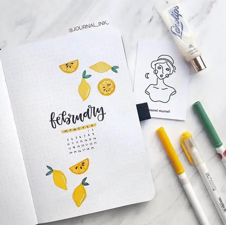 Realistic red strawberries illustrated on a simple bullet journal cover page for February.