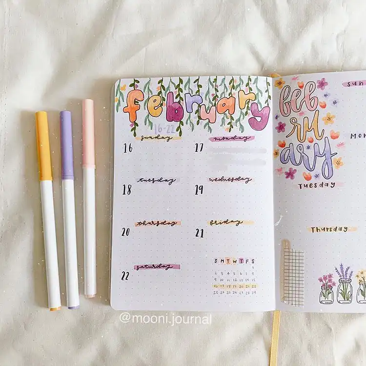 Delicate watercolor flowers in unique hues adorning a February bullet journal cover page.